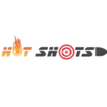 Eine Gruppe von Kindern spielt Fußball auf einem kleinen Spielfeld. Im Hintergrund sind Erwachsene zu sehen, die das Spiel beobachten.